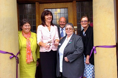 Lesley Griffiths AM cuts the ribbon at the opening of Hillbury House watched byLiz Rees, Mario Kreft, Anita Curley and Barbara Hale