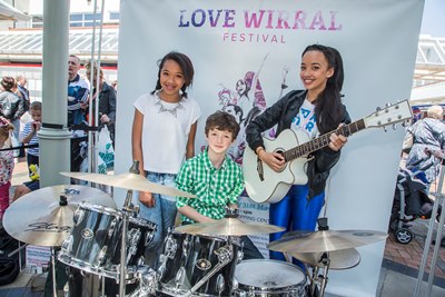 Love Wirral Festival at the Pyramids Shopping Centre, Birkenhead. Singer Tabitha Jade, with drummer Seth Beard and backing singer Eliza Mai