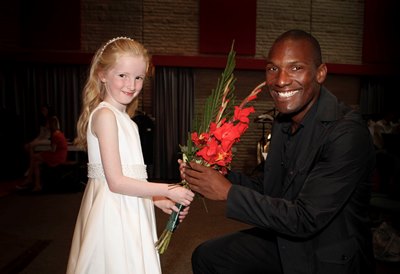 American Singer Noah Stewart receives a gift of flowers from 7 year old Annie Roberts a pupil at Garth primary school