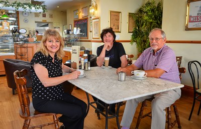 SR110714A Cyfnod Cafe Bala with owners Gareth and Eleri Evans, were visitef by John Davies (Purple Shirt) of The Energy Company. The cafe was miss-billed by a huge amount, almost £50K, but the Energy Company identified the miss-billing and got them a reduction of over £40K in their bill.