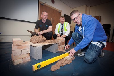 Cartrefi Conwy Construction taster session at the Construction taster session at the Ty Llywelyn Community Centre Llandudno. Pictured is Eddie Connor trying out the brick laying with Paul Kenyon, Llandrillo College and Mike Rutter Cartrefi Conwy.